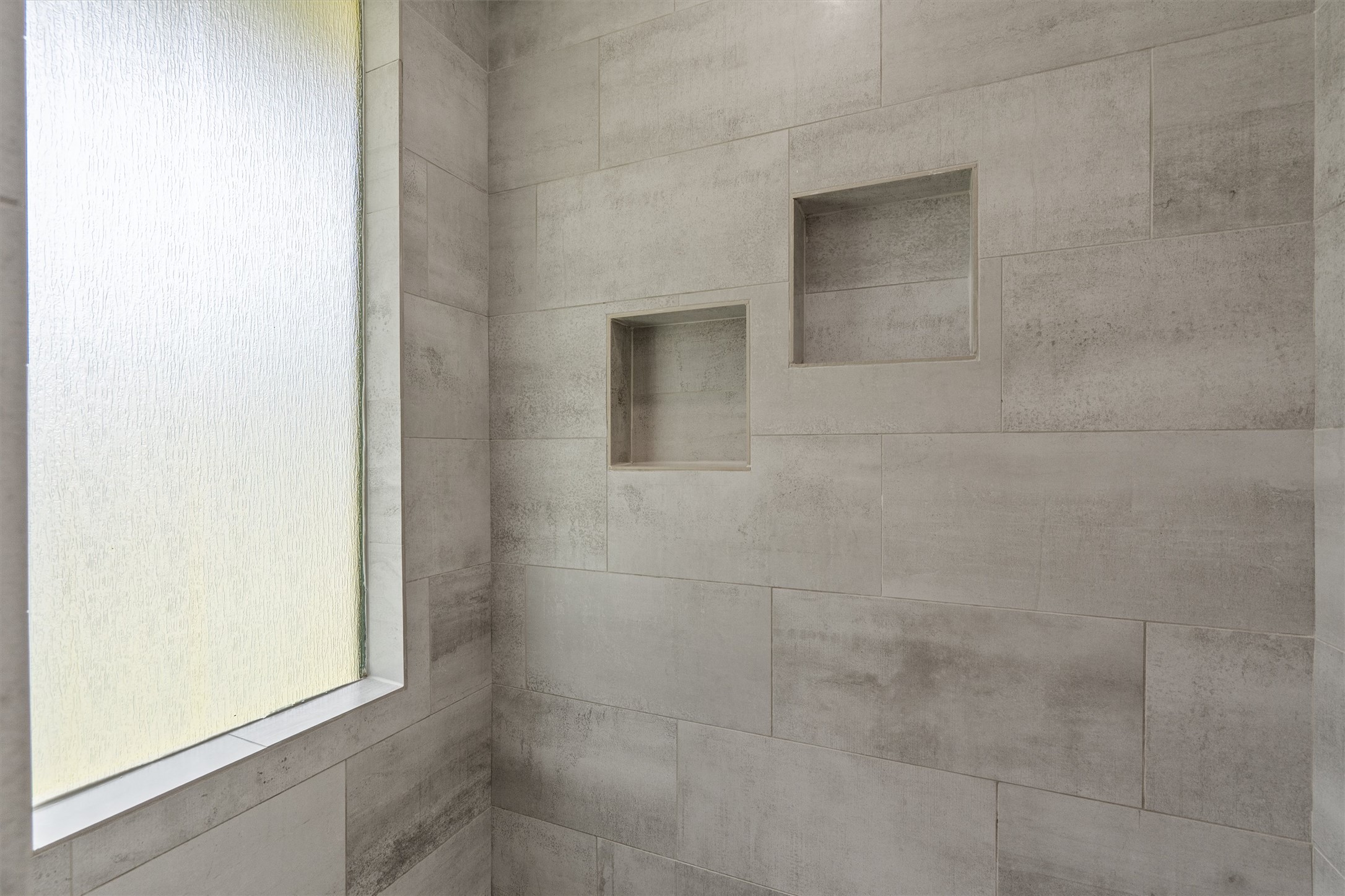 7707 Robalo Road Austin, TX 78757 - Photo 18 of 33 A well-lit shower area features recessed niches and a privacy window.