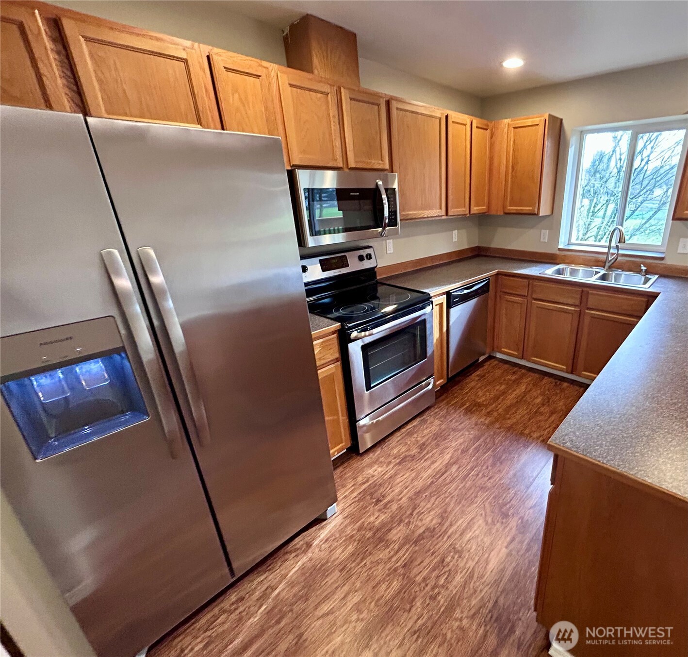 17254 153rd Street Southeast Monroe, WA 98272 - Photo 6 of 17 a kitchen with granite countertop a refrigerator a sink a stove a microwave a counter top and cabinetry