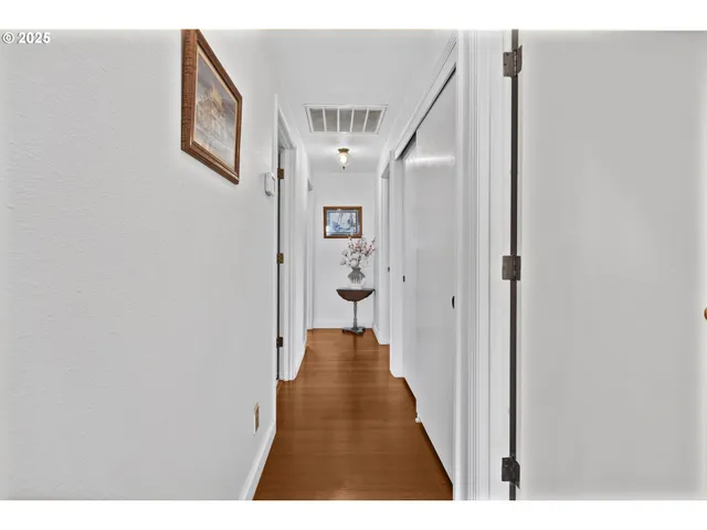 a view of a hallway with wooden floor and staircase