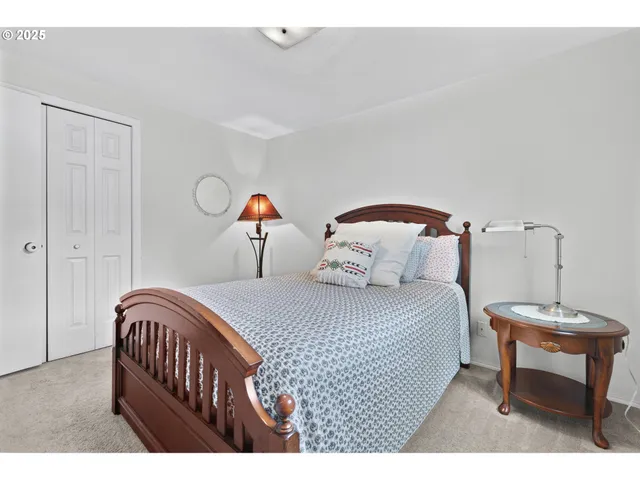 a bedroom with a bed a table and painting