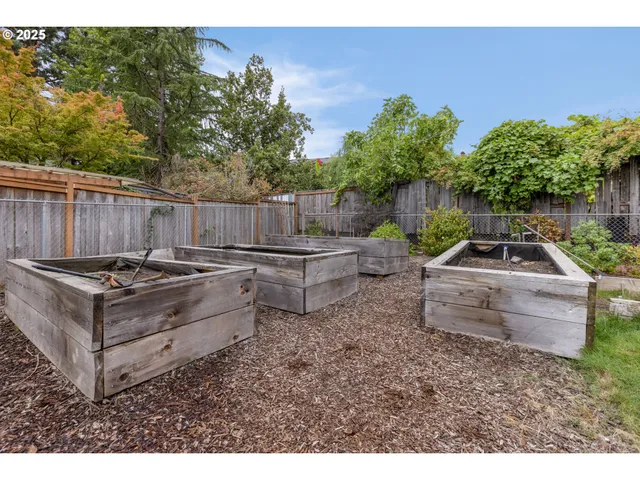 a view of a backyard with a white fence