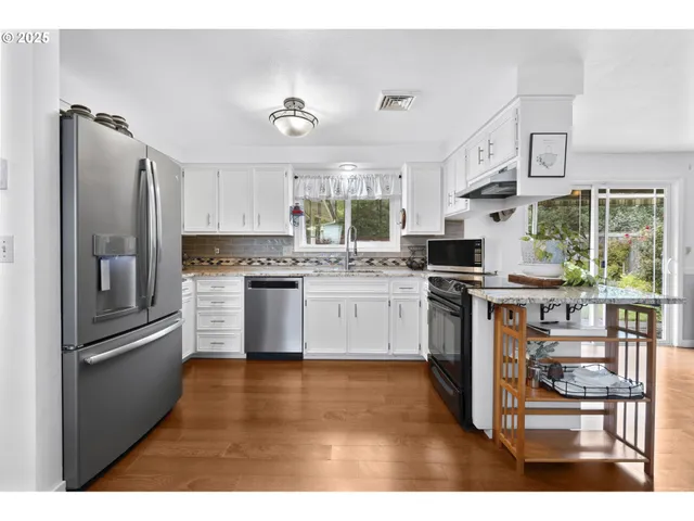 a kitchen with white cabinets and appliances