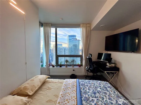 a bedroom with a bed and large windows