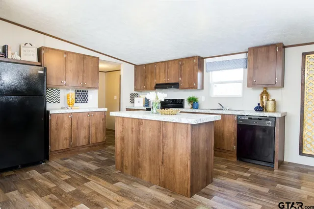 a kitchen with granite countertop a refrigerator stove top oven and sink