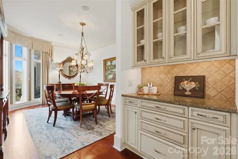 a view of a dining room and livingroom with furniture wooden floor a chandelier