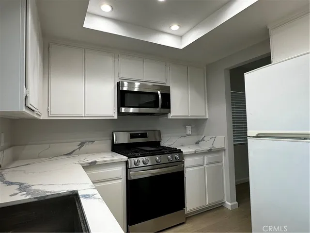 a kitchen with cabinets stainless steel appliances and a sink