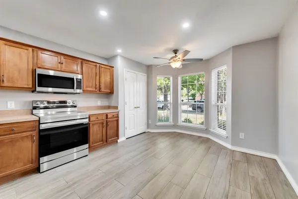 a view of kitchen with sink a microwave and cabinets