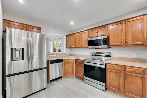 a kitchen with stainless steel appliances granite countertop a refrigerator stove a sink and microwave