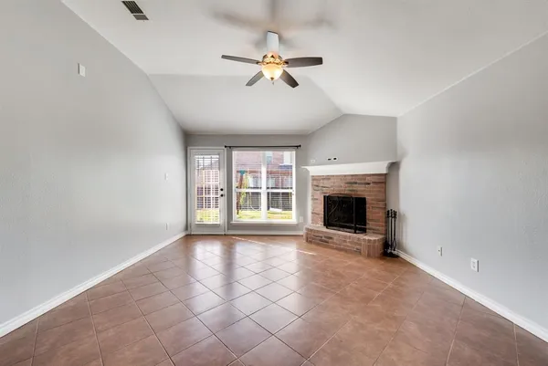 a view of an empty room with a fireplace and a window
