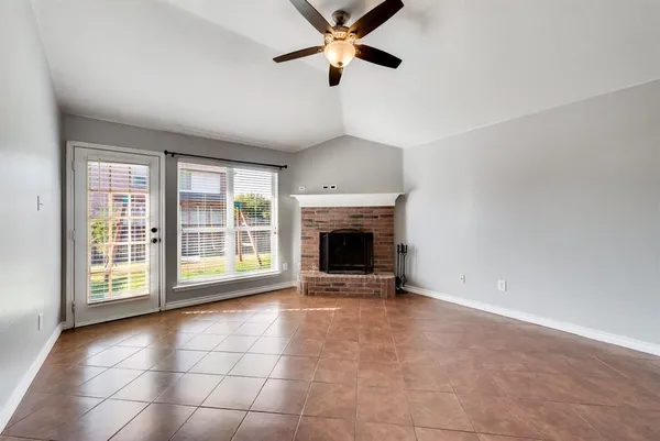a view of an empty room with a fireplace and a window