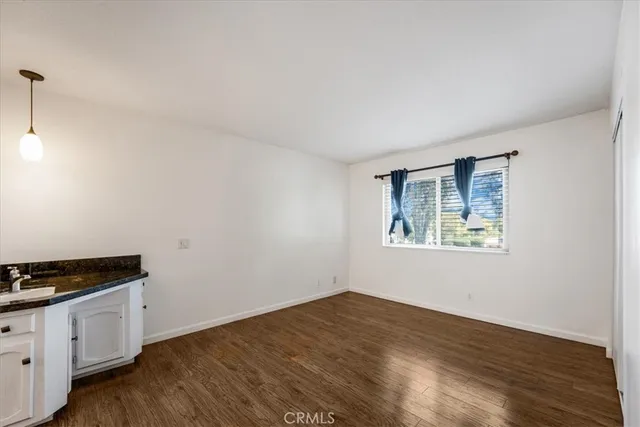 a view of a kitchen with wooden floor and a sink