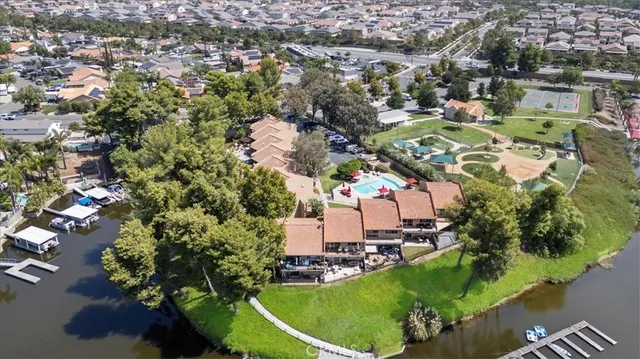 an aerial view of ocean and residential houses with outdoor space