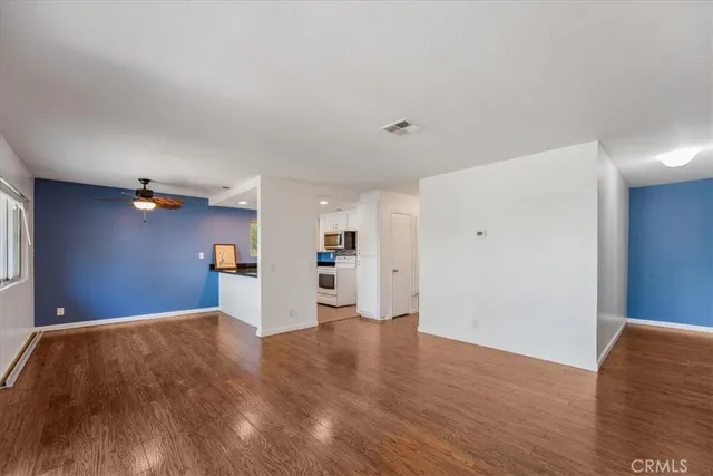 a view of empty room with wooden floor and windows