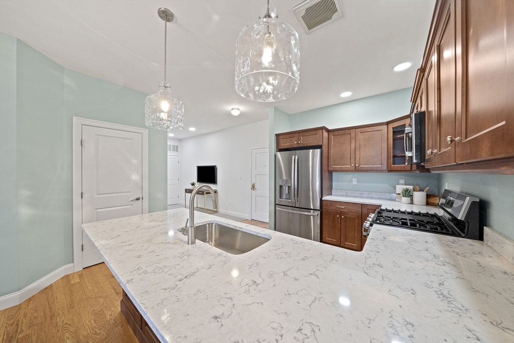 15 Revolution Way, Unit 2107 Canton, MA 02021 - Photo 11 of 40 a kitchen with stainless steel appliances granite countertop a sink refrigerator and cabinets