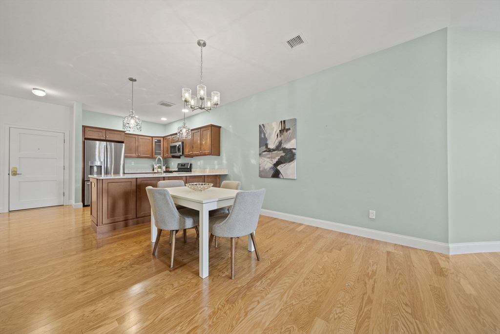 15 Revolution Way, Unit 2107 Canton, MA 02021 - Photo 13 of 40 a view of a dining room with furniture and wooden floor
