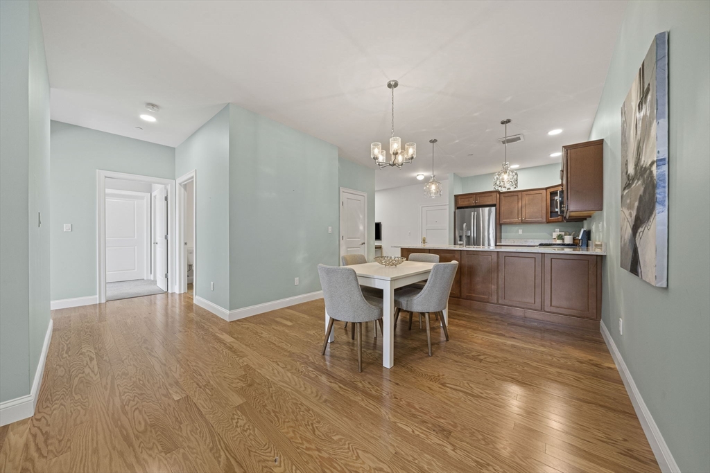 15 Revolution Way, Unit 2107 Canton, MA 02021 - Photo 14 of 40 a view of a dining room with furniture and wooden floor