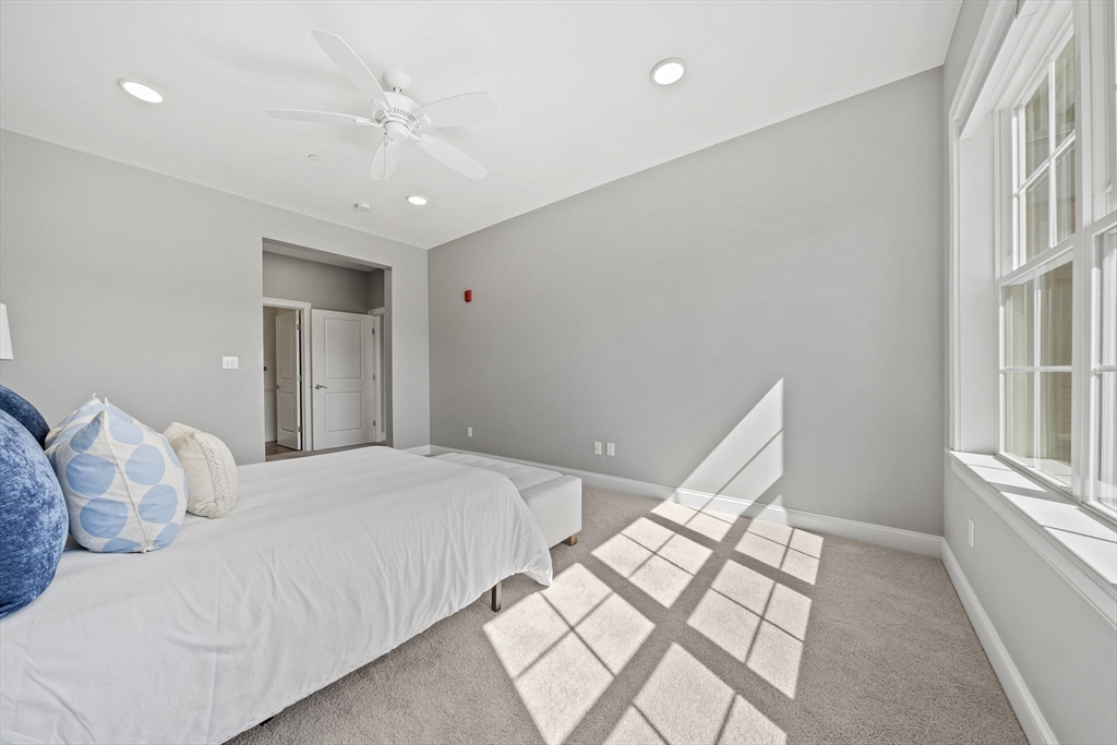 15 Revolution Way, Unit 2107 Canton, MA 02021 - Photo 22 of 40 a bedroom with a large bed and a chandelier