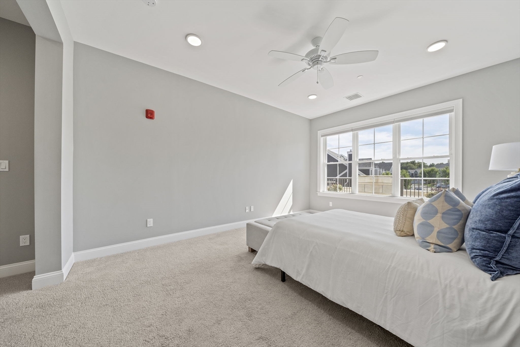 15 Revolution Way, Unit 2107 Canton, MA 02021 - Photo 23 of 40 a bedroom with a bed and a large window