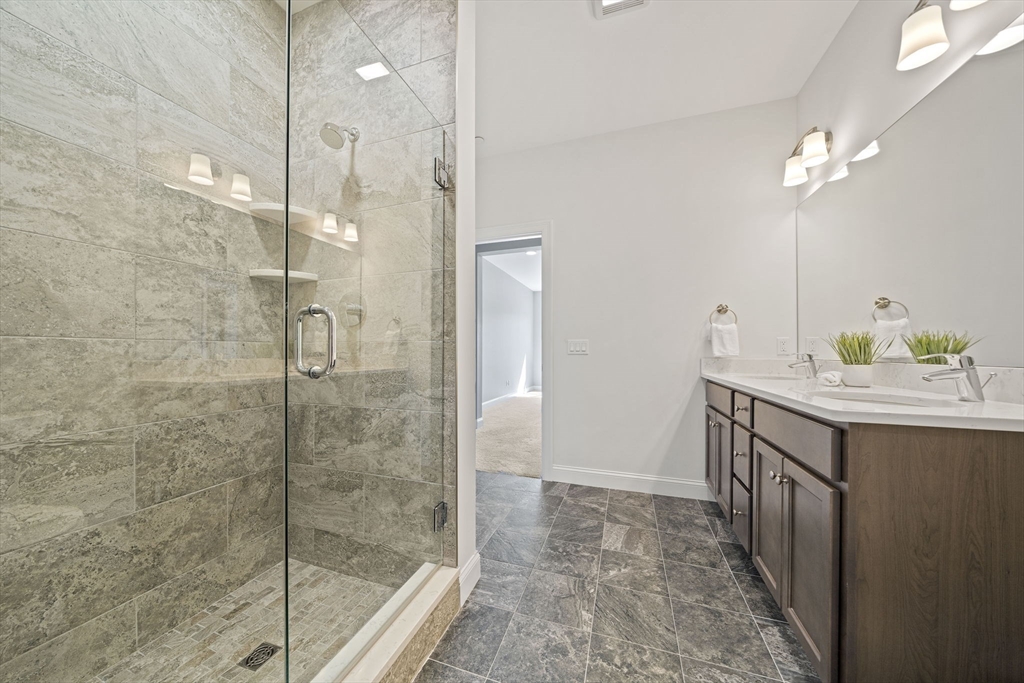 15 Revolution Way, Unit 2107 Canton, MA 02021 - Photo 25 of 40 a bathroom with a granite countertop sink a mirror and a shower