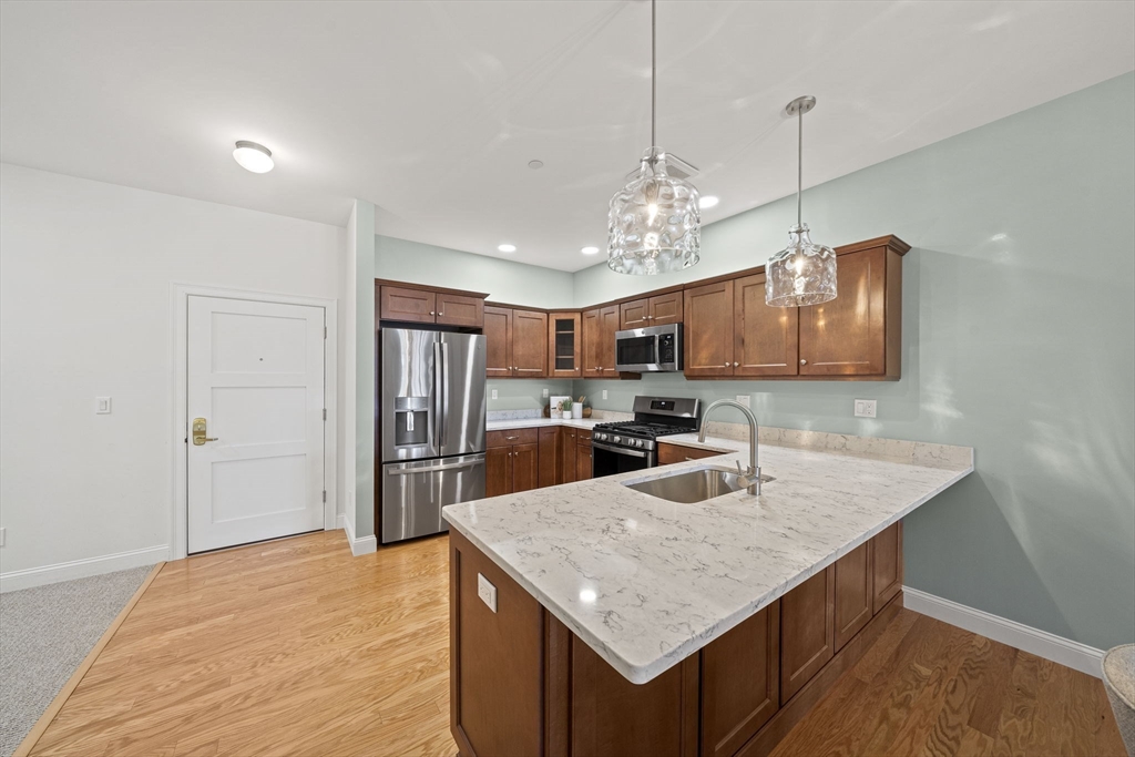 15 Revolution Way, Unit 2107 Canton, MA 02021 - Photo 10 of 40 a kitchen with stainless steel appliances granite countertop a sink refrigerator and microwave