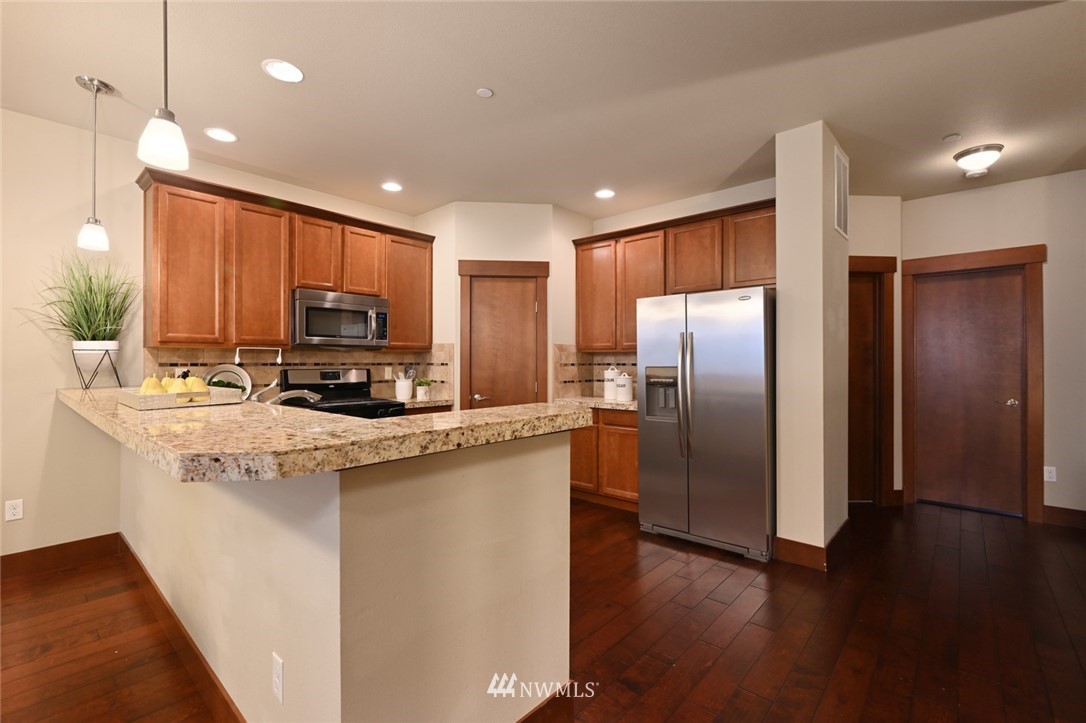 3805 Northeast 3rd Place Renton, WA 98056 - Photo 8 of 30 a kitchen with stainless steel appliances a refrigerator sink microwave and cabinets
