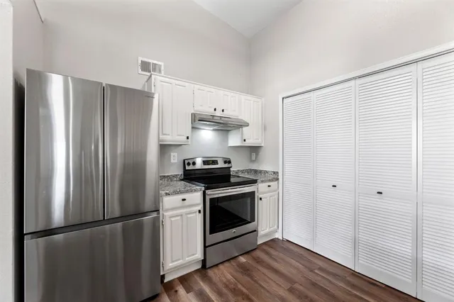a kitchen with stainless steel appliances a refrigerator sink and cabinets