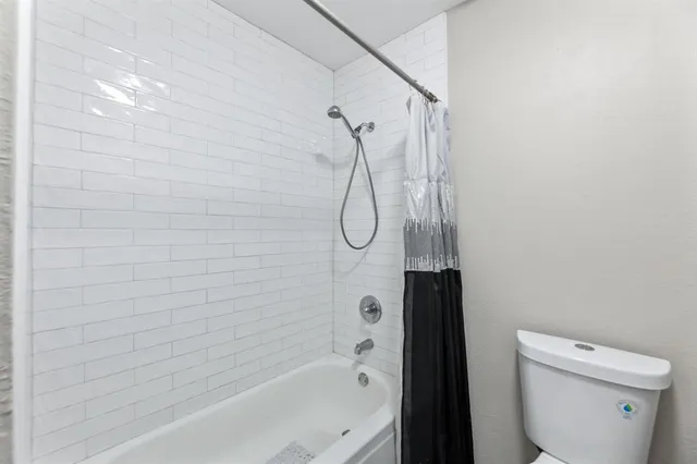 a bathroom with a shower a toilet and a shower