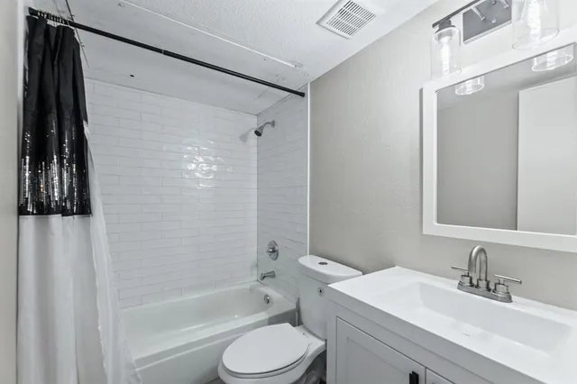 a bathroom with a sink a toilet a mirror and shower