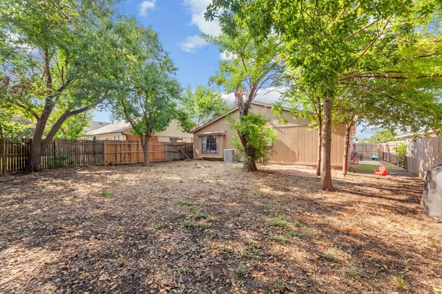 a view of a house with a yard and tree