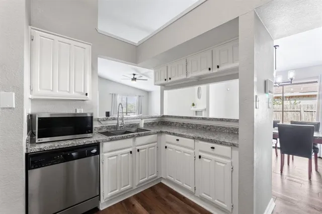 a kitchen with granite countertop a sink and cabinets