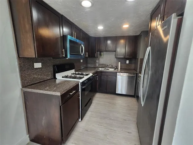a kitchen with a sink stove and microwave