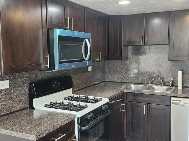 a kitchen with stainless steel appliances granite countertop a refrigerator and a sink