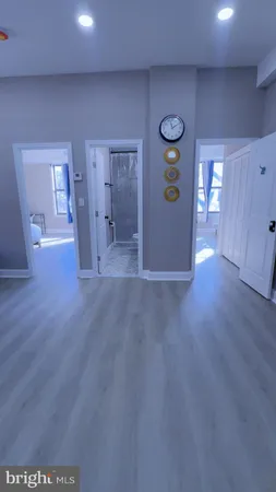 a view of an empty room with wooden floor and windows