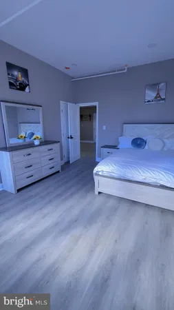 a spacious bedroom with a bed and a dresser
