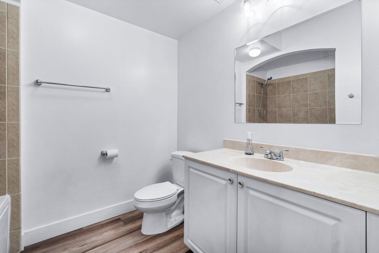 1117 Renaissance Way, Unit 117 Boynton Beach, FL 33426 - Photo 16 of 31 a bathroom with a toilet sink and mirror