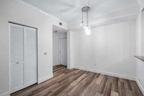 a view of a room with wooden floor and white walls