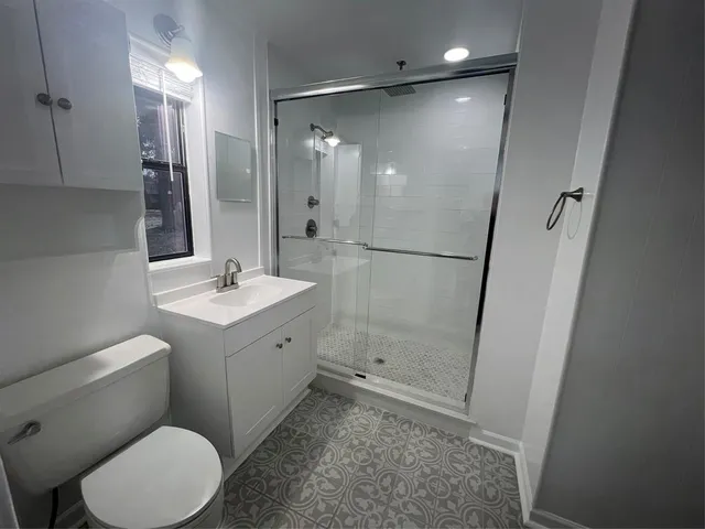 a bathroom with a sink mirror vanity and toilet