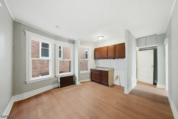 a view of a livingroom with a fireplace cabinet and windows