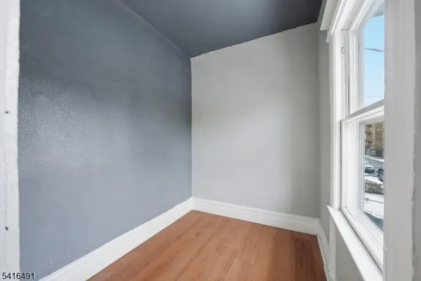 a view of a small space with wooden floor and a window