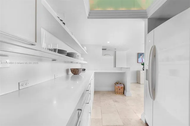 a view of a kitchen with refrigerator and window