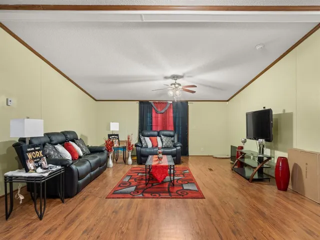 a living room with furniture a wooden floor and a flat screen tv