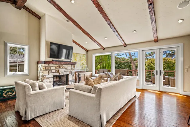 a living room with furniture wooden floor and a large window