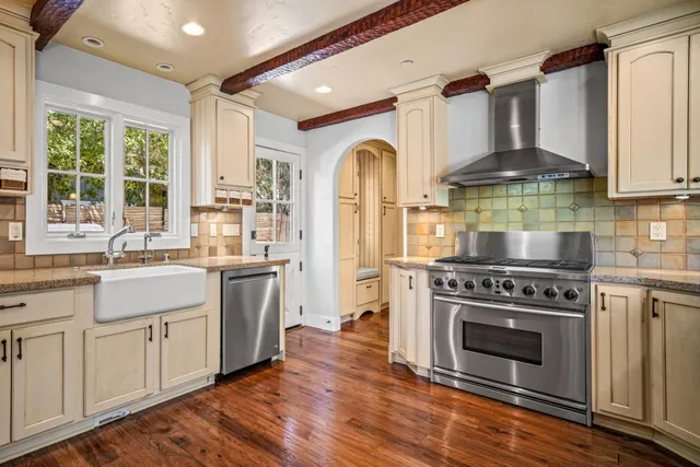 a kitchen with stainless steel appliances a stove a sink and a refrigerator