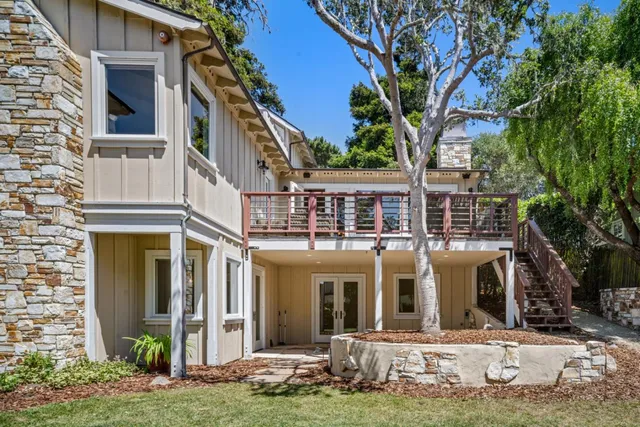 a view of a house with backyard and wooden fence