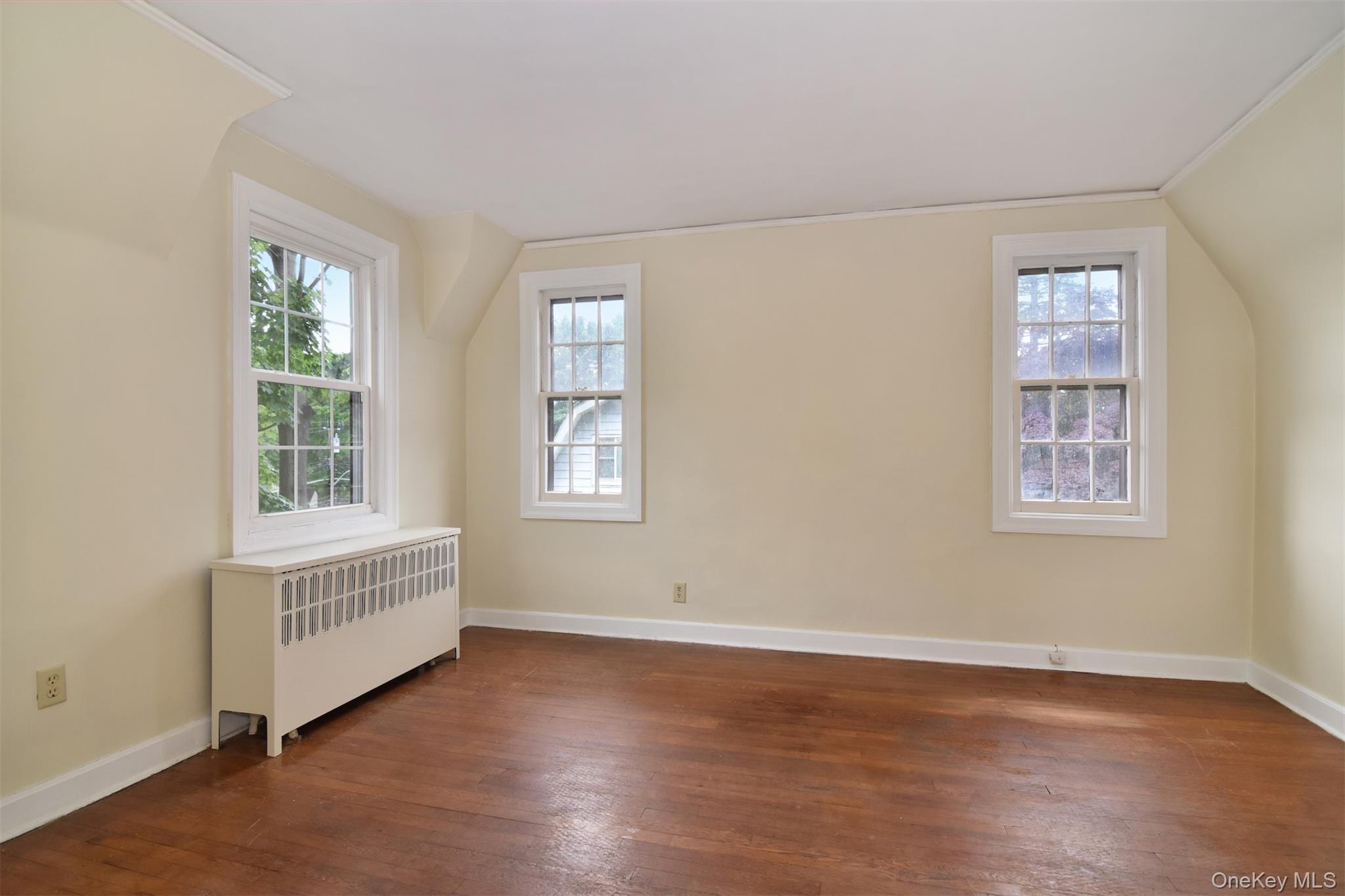 370 Scarsdale Road Tuckahoe, NY 10707 - Photo 21 of 25 Room featuring three double-hung windows, rich hardwood flooring, and a white radiator cover