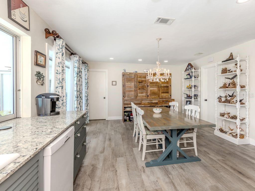 601 Apalachicola Road Venice, FL 34285 - Photo 14 of 33 a kitchen with stainless steel appliances granite countertop table chairs and wooden floor