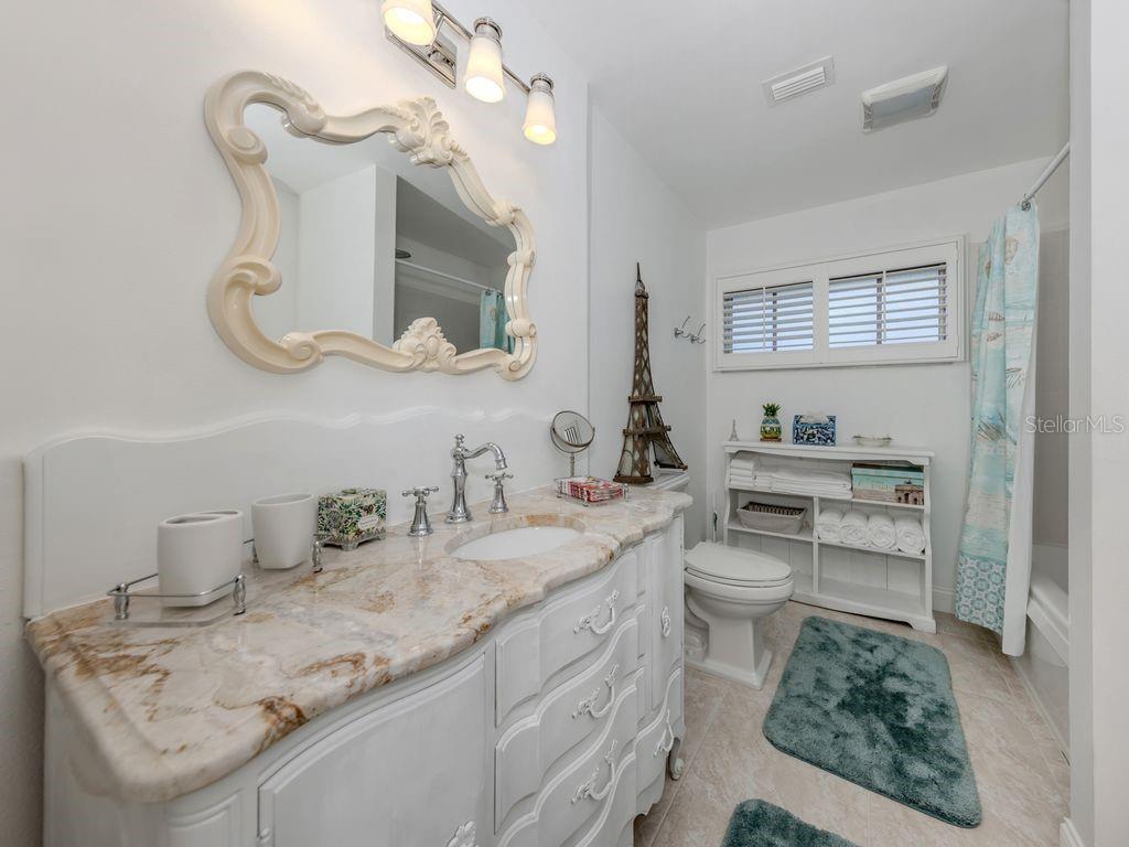 601 Apalachicola Road Venice, FL 34285 - Photo 22 of 33 a bathroom with a granite countertop sink mirror and vanity