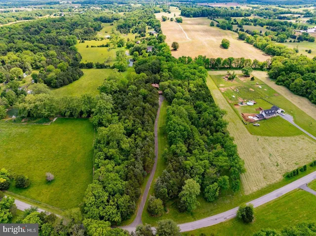 an aerial view of a residential houses with outdoor space and river view