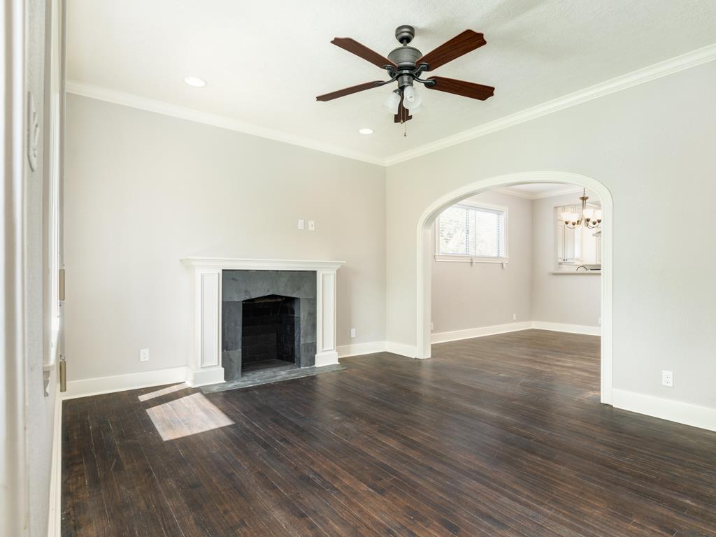 4528 Avenue R 1/2 Galveston, TX 77551 - Photo 11 of 22 an empty room with wooden floor a ceiling fan and fireplace