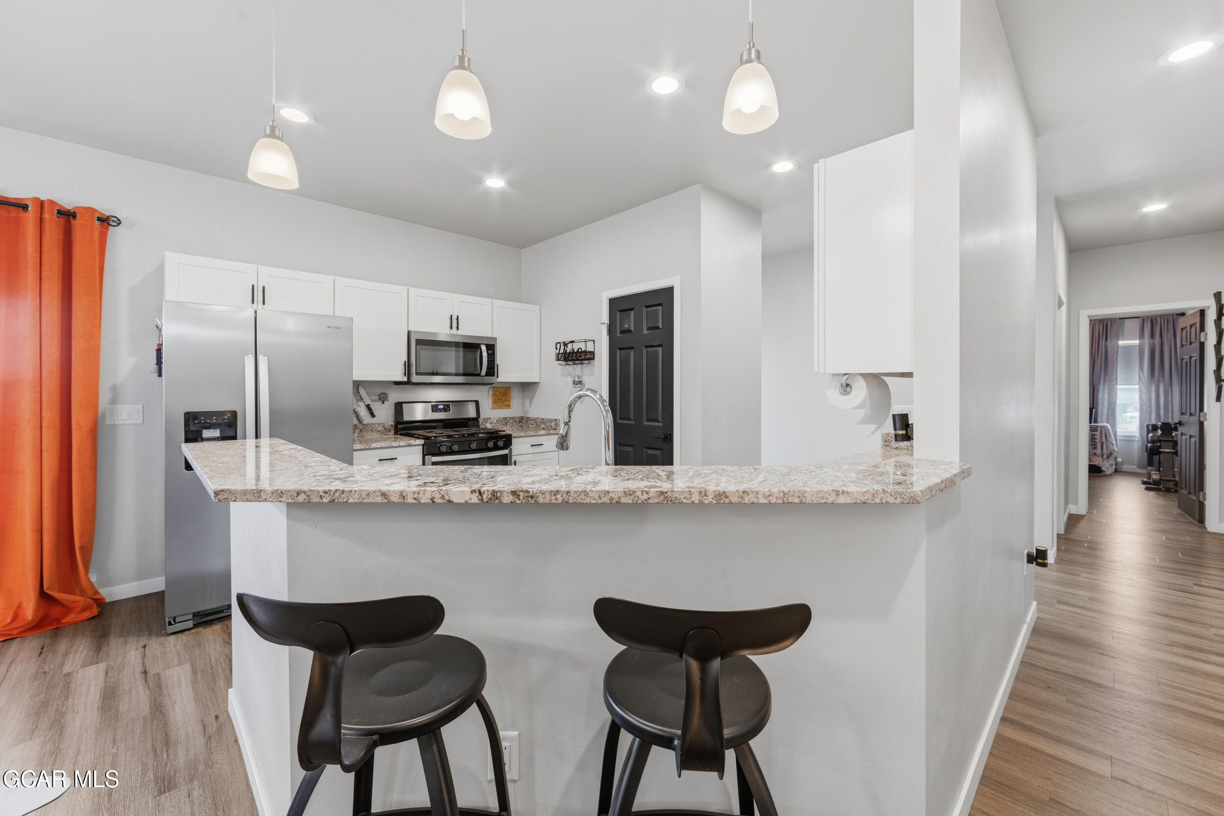 503 12th Street, Unit B Kremmling, CO 80459 - Photo 7 of 44 a kitchen with stainless steel appliances a dining table chairs refrigerator and microwave